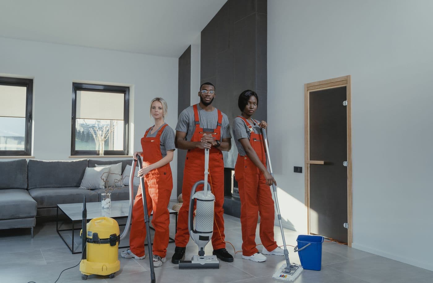 Professional cleaning team with vacuums and mop ready for a house cleaning visit
