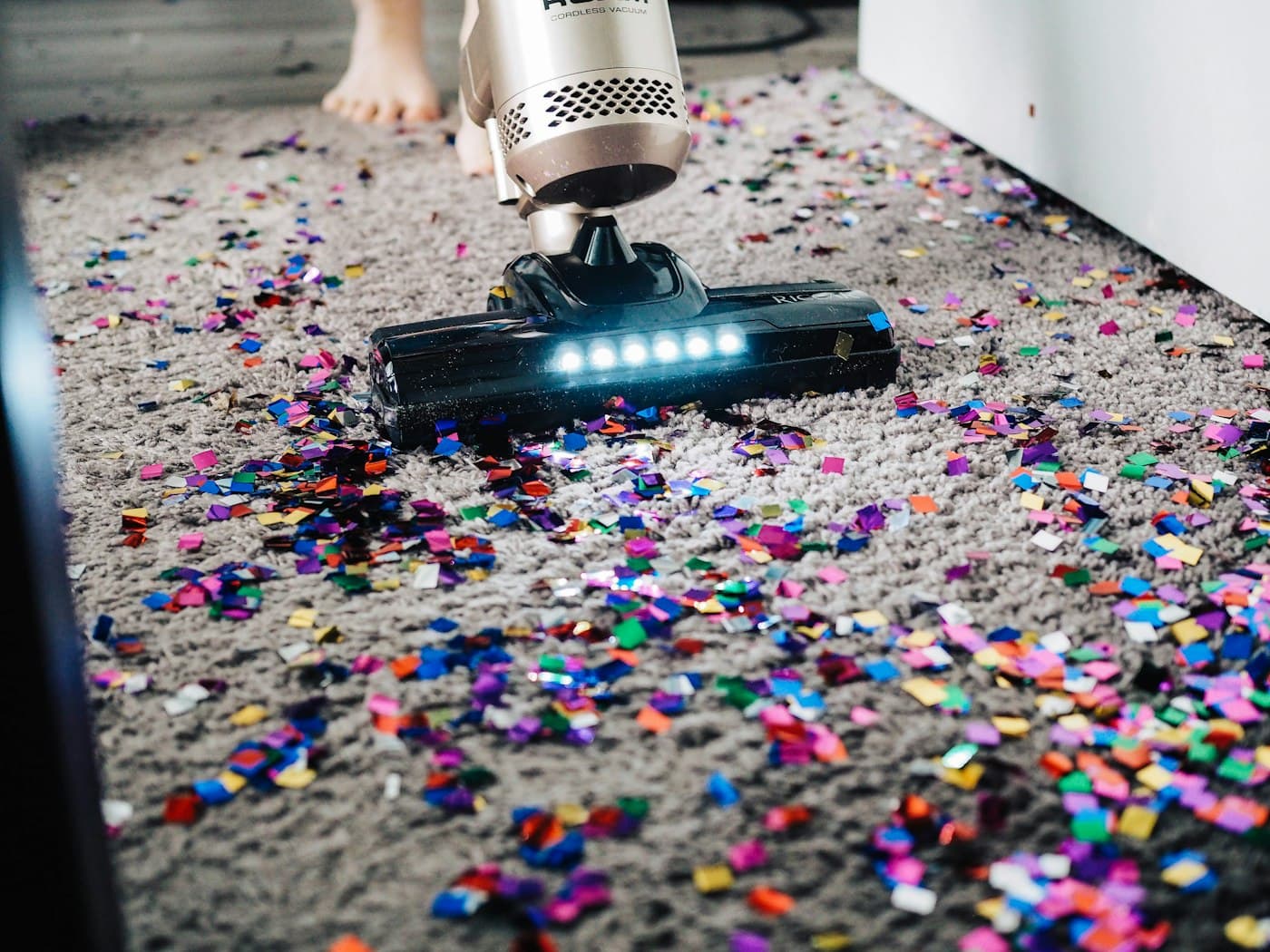 Vacuum clearing colorful confetti from carpet after an event